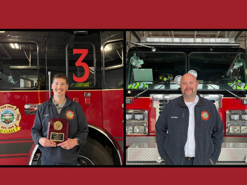 2 firefighters standing in front of a fire engine