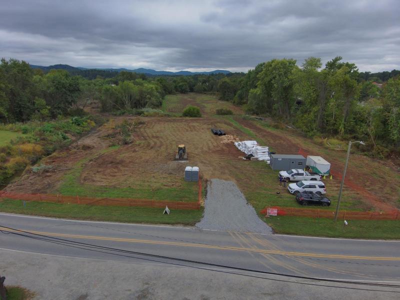 Field beside lower mud creek showing construction supplies and vehicles