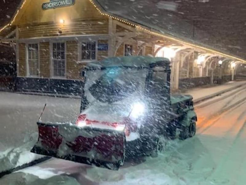 Vehicle plowing snow in front of the train depot