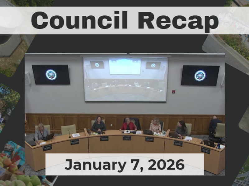 City Council members sit a rounded dias. 