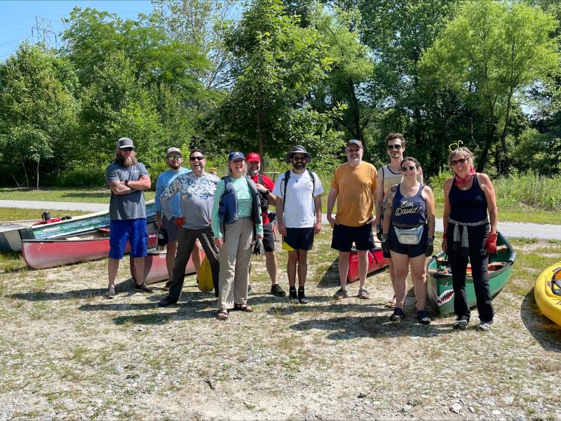 Group of volunteers outside, smiling during a stream cleanup event.