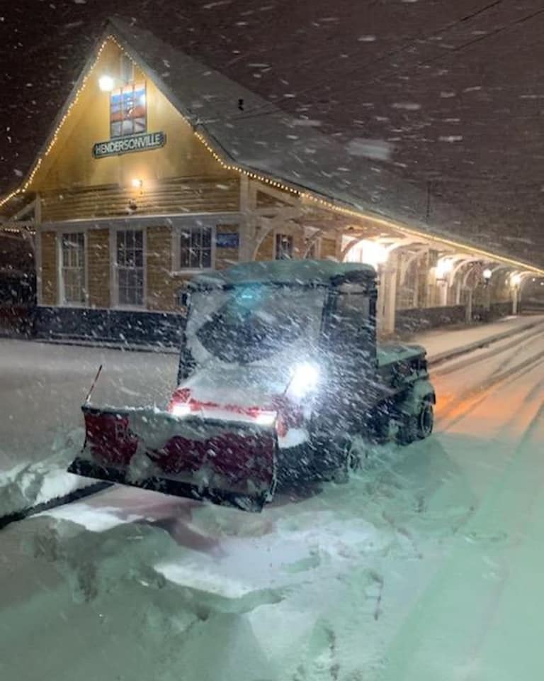 Vehicle plowing snow in front of the train depot