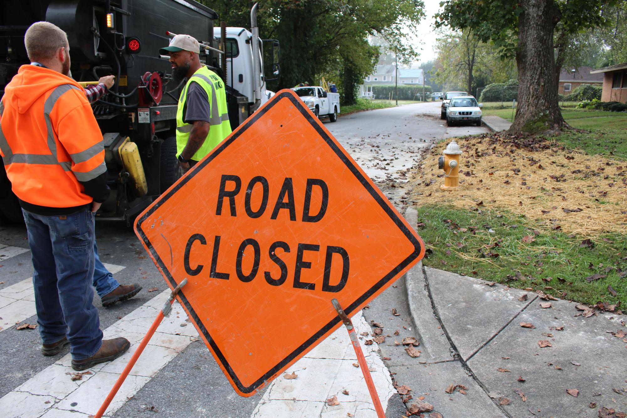 Road closed sign with Public Works staff