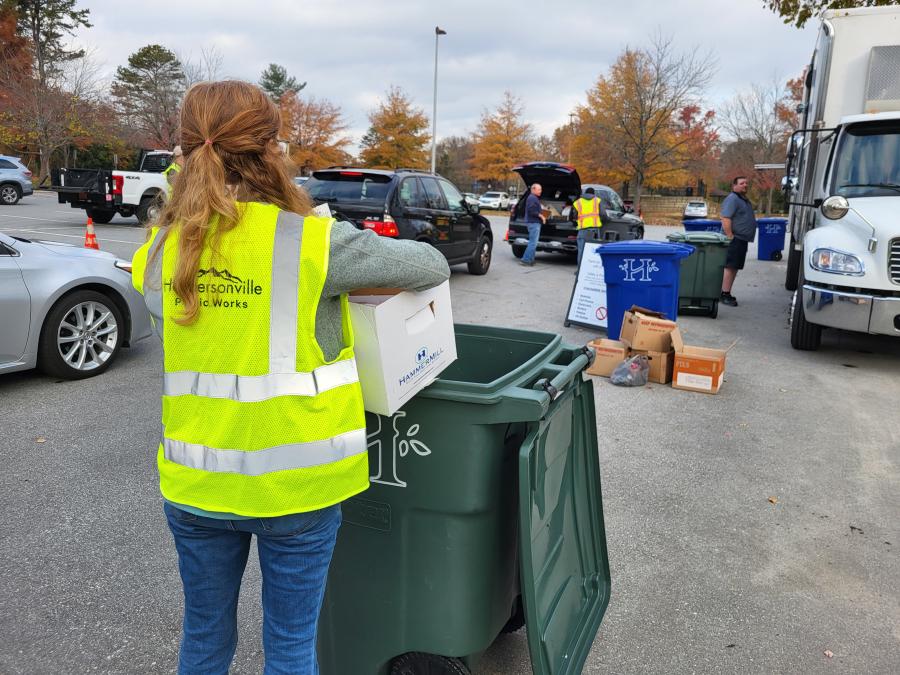 Girl recycling papers at Hendersonville's annual Shred Day Event