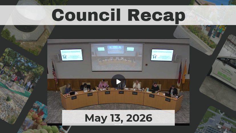 Council members are seated around a dais. 
