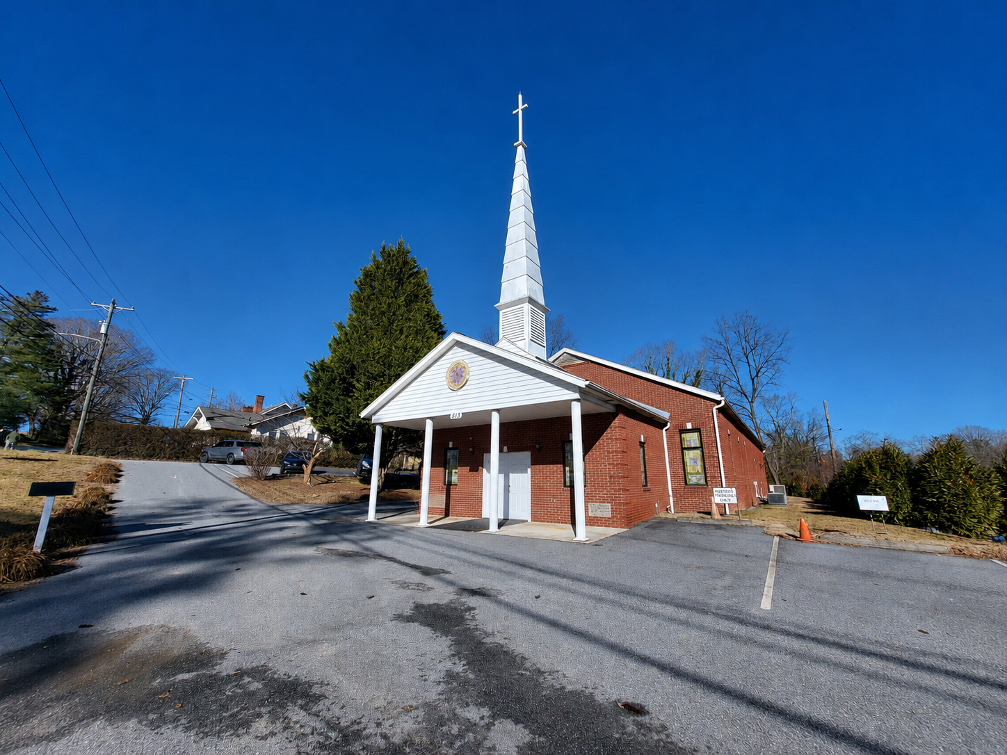 A church with a white steeple, with a clear blue sky in the background.